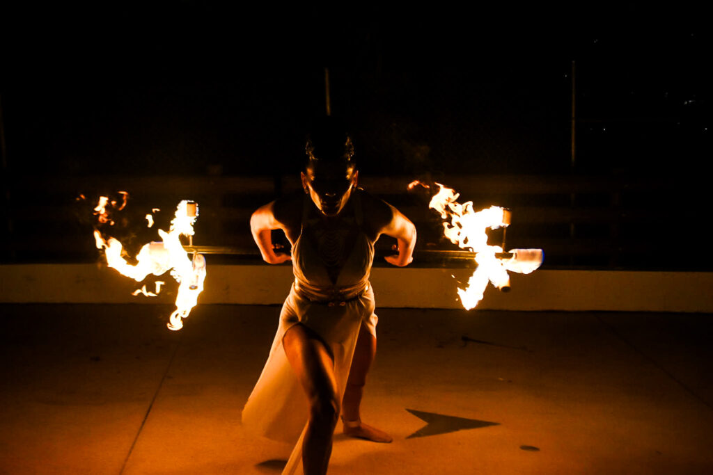 Fire performers from Aura Entertainment spinning flames with precision during a South Florida event.