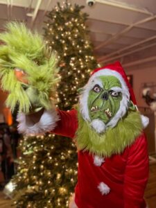 Holiday event featuring a festive character performer in full costume creating a playful and immersive holiday event experience produced by Aura Entertainment in South Florida